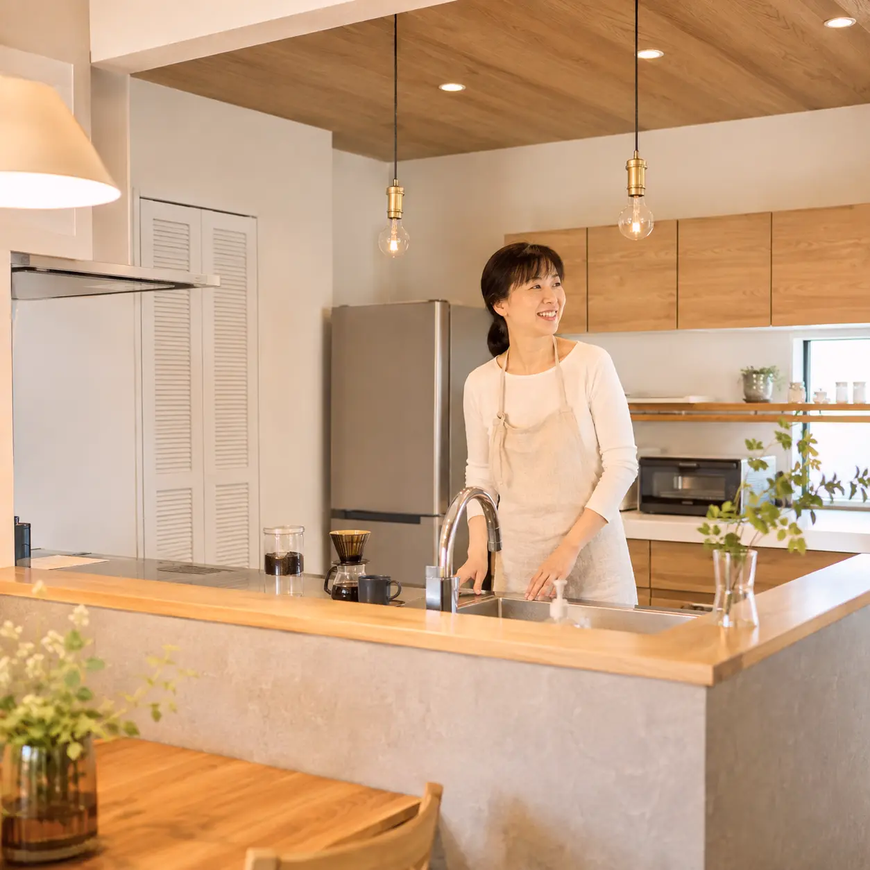 改装したキッチンに立つ住まい手